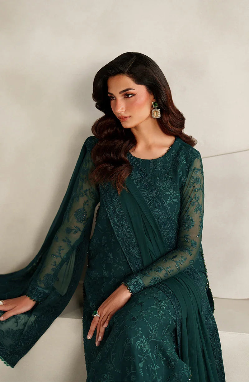 Woman wearing a dark green embroidered outfit against a neutral background