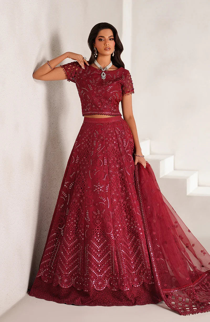 Woman wearing a red embroidered outfit against a white background