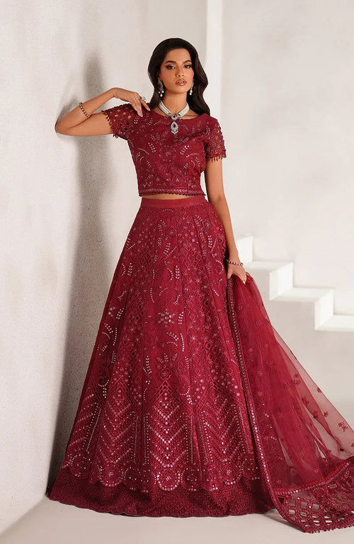 Woman wearing a red embroidered outfit against a white background