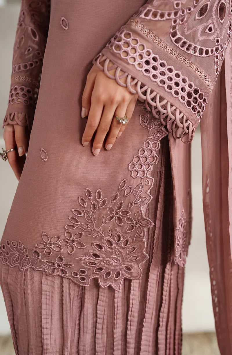 Close-up of a mauve dress with intricate lace detailing on a neutral background