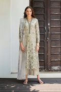 Woman wearing a light green floral dress with a matching dupatta in front of a wooden door.