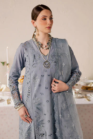 Woman wearing a gray embroidered outfit with jewelry in an elegant setting.