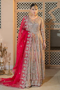 A woman wearing a traditional, double-layered maxi set with peach and red colors, featuring intricate embellishments and a dupatta with a mathapatti design.