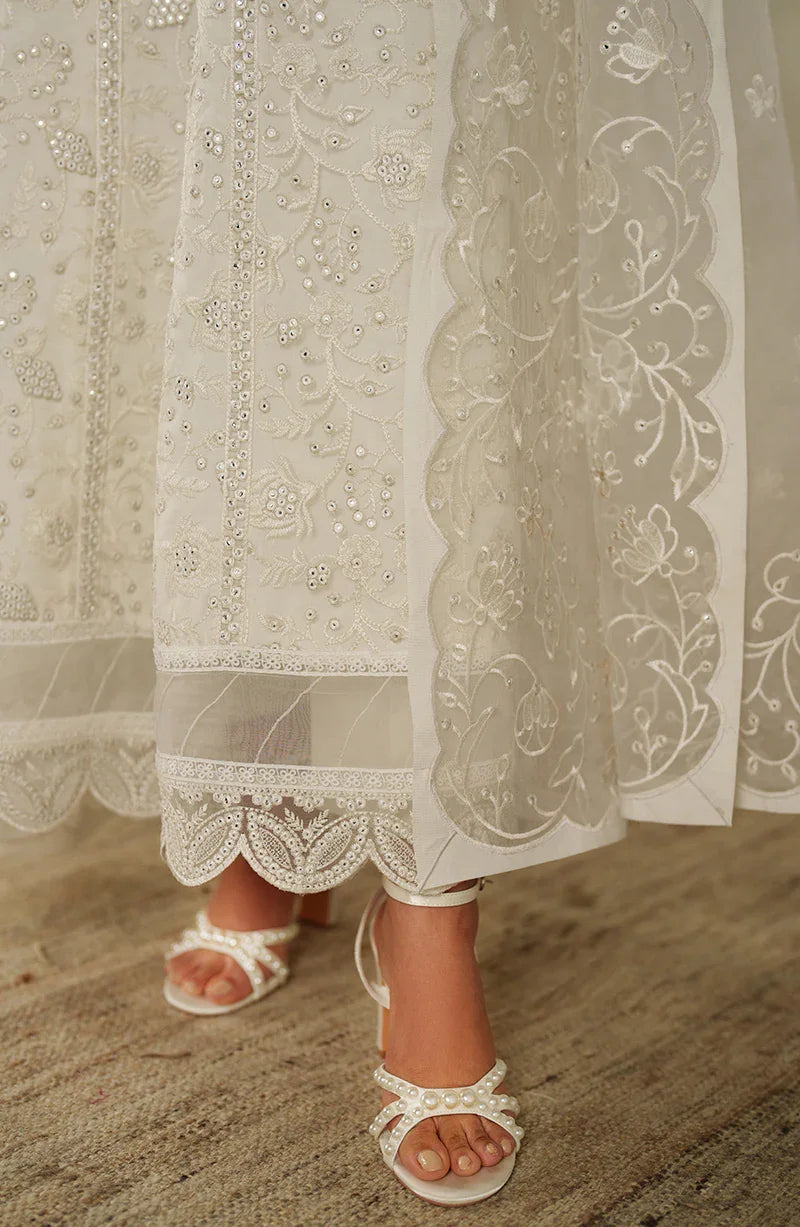 Lace-trimmed dress with sandals on a neutral background