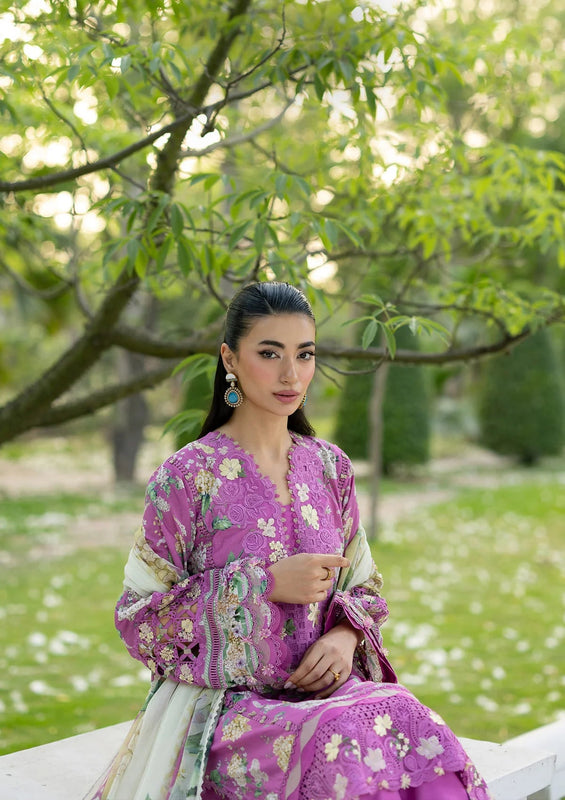Woman in a purple floral dress sitting outdoors with greenery in the background