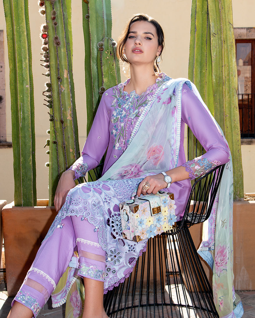 Woman in a floral outfit sitting on a chair with cacti in the background
