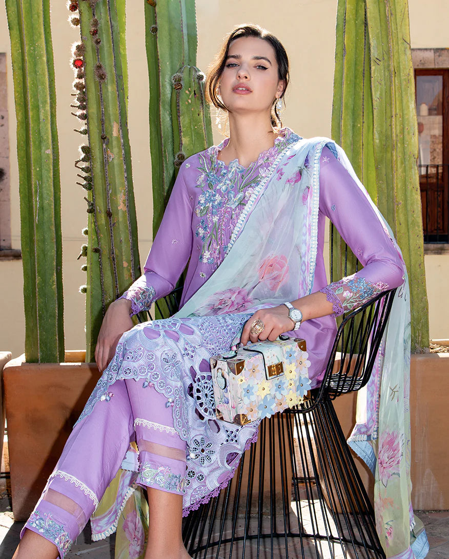 Woman in a floral outfit sitting on a chair with cacti in the background