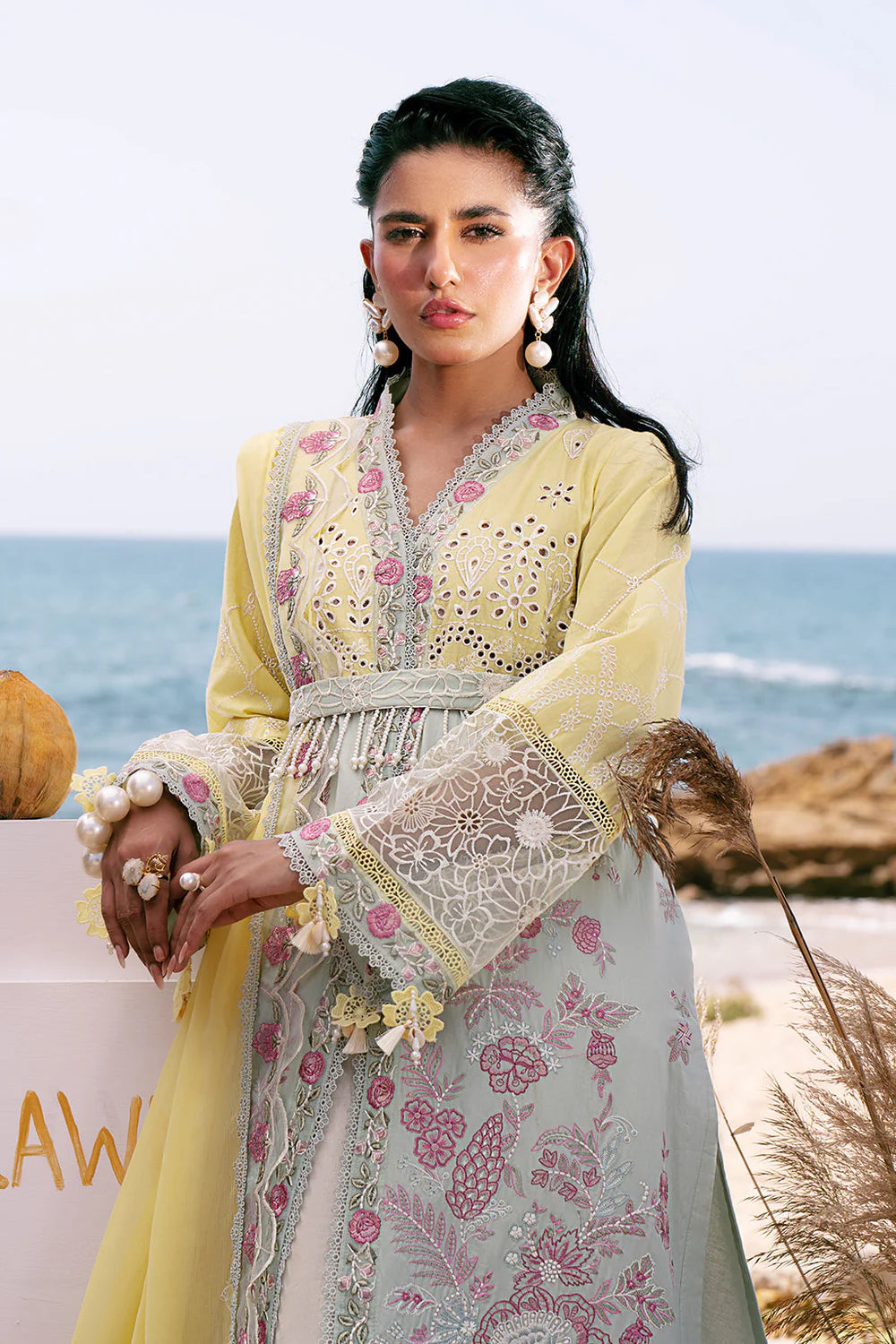 Woman in traditional outfit with ocean in the background