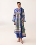 Woman wearing a blue floral dress with a patterned jacket on a white background