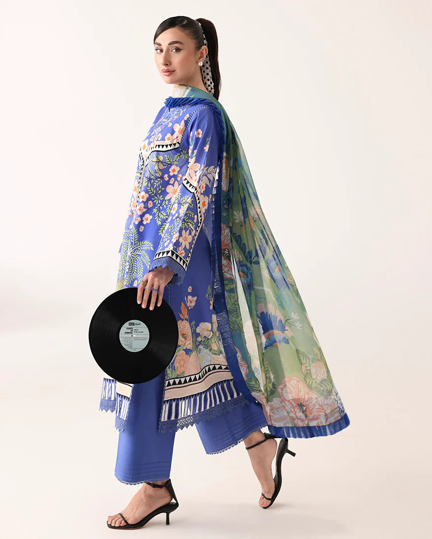 Woman wearing a blue and green floral outfit holding a vinyl record on a white background