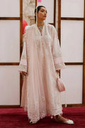 Woman in a traditional outfit with lace details standing against a wooden panel background.