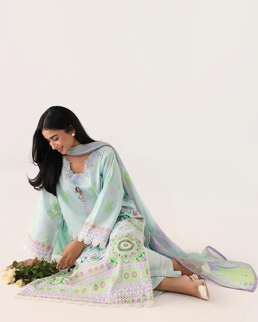 Woman in a floral dress with a matching scarf holding flowers on a white background