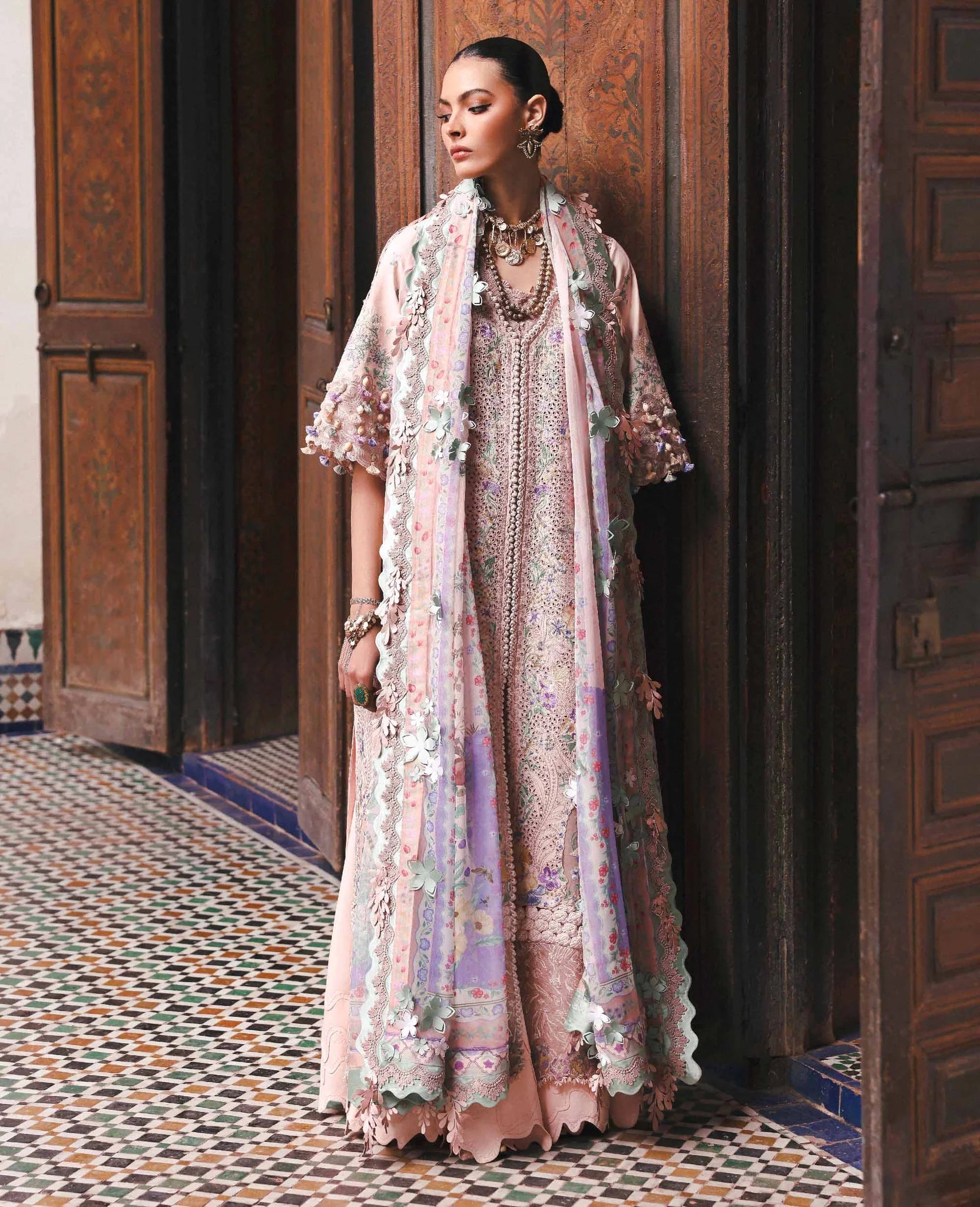 Woman in a floral dress standing in a decorative interior setting