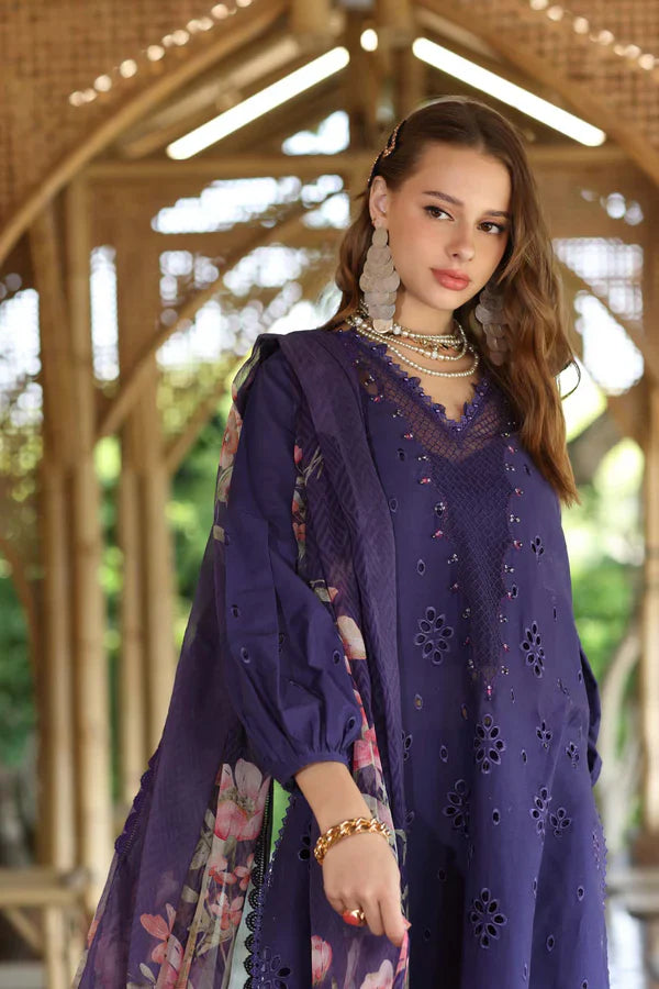 Woman wearing a purple embroidered outfit with floral patterns in an outdoor setting.