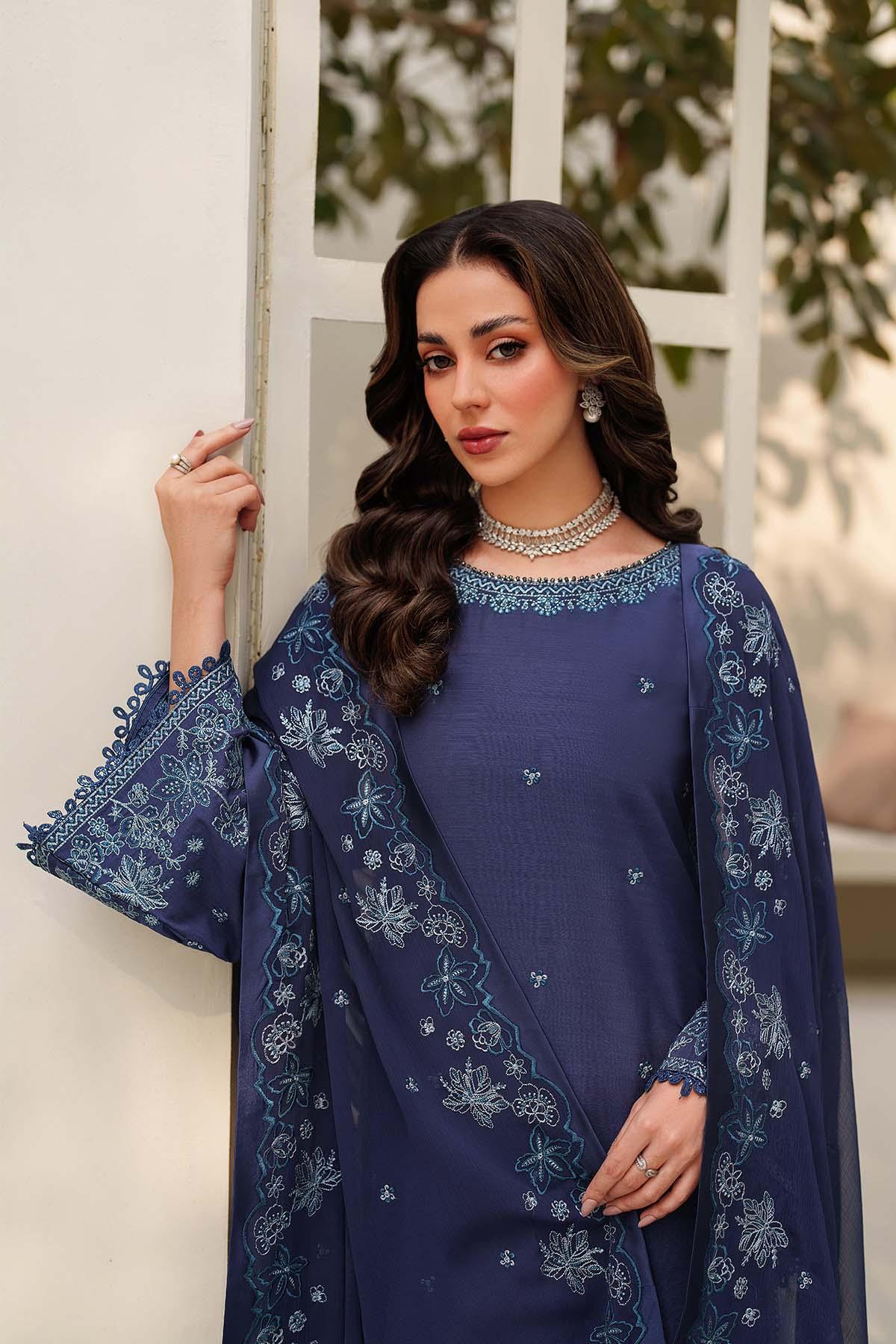 Woman wearing a blue embroidered outfit with a white background