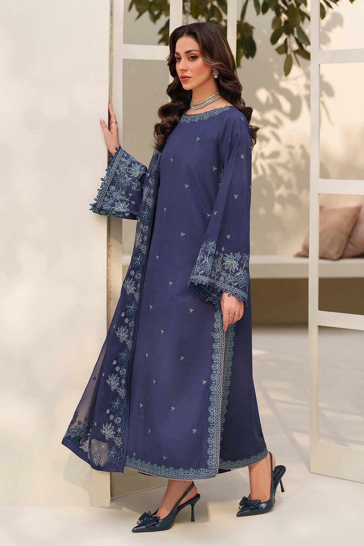 Woman wearing a blue embroidered outfit in an indoor setting