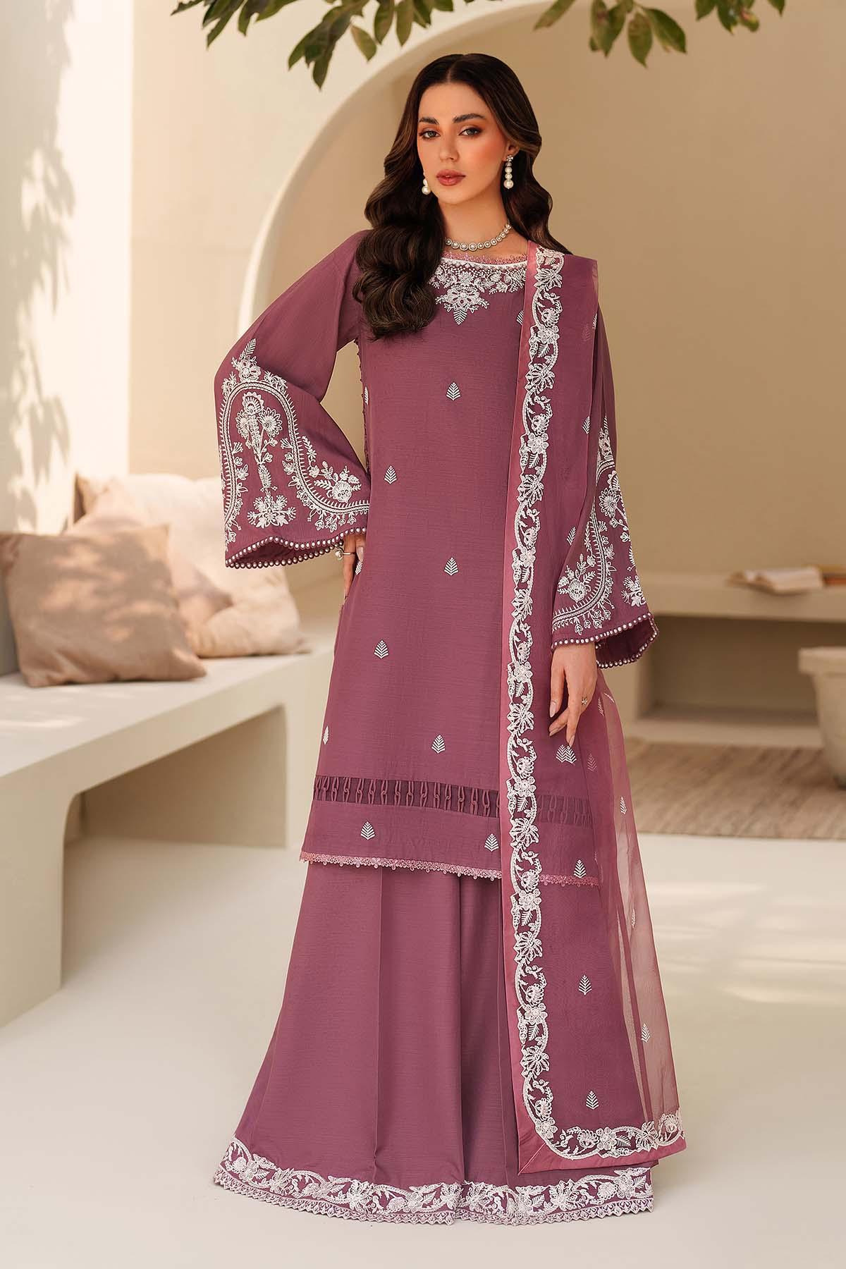 Woman wearing a purple embroidered traditional outfit in an outdoor setting.