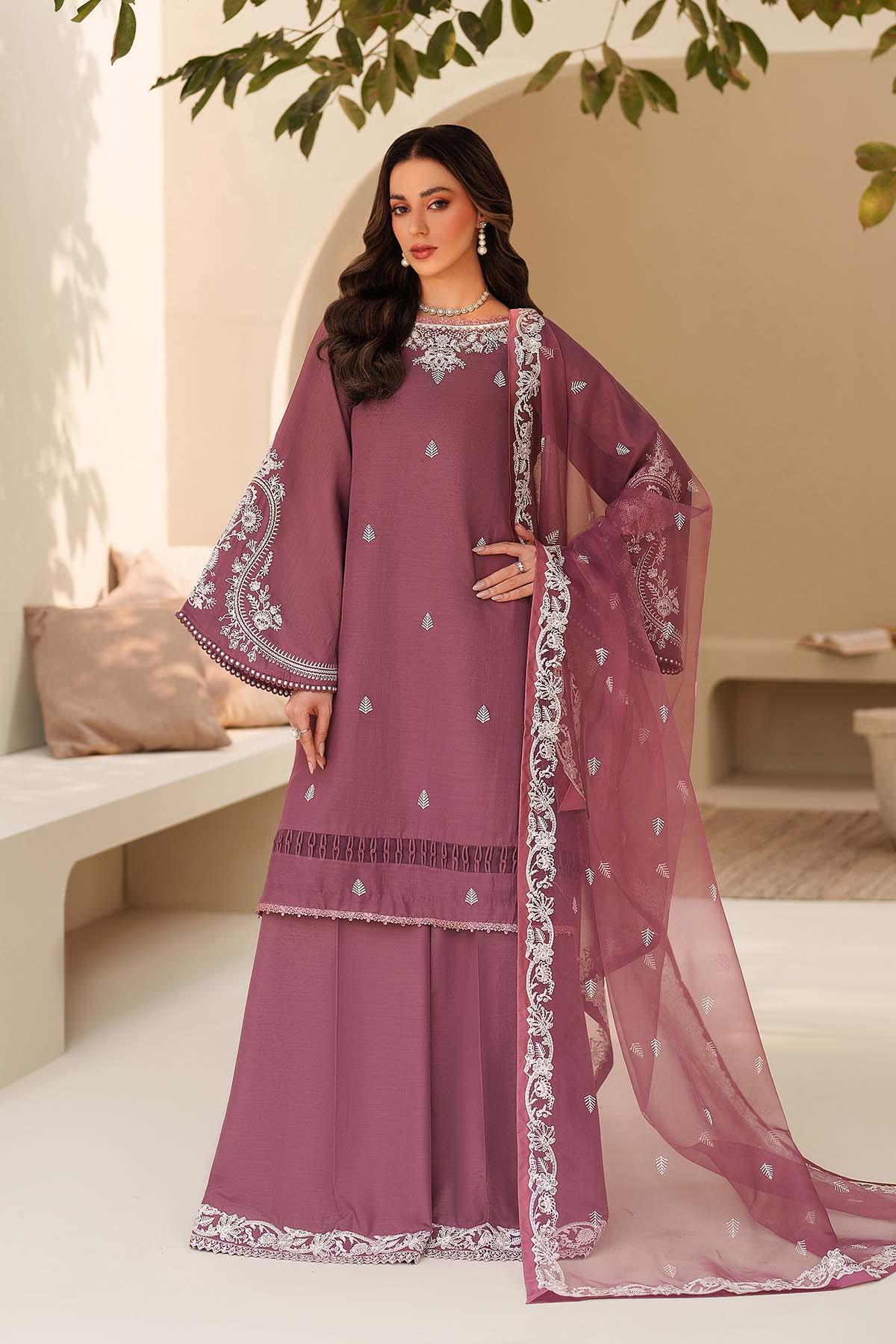 Woman wearing a purple traditional outfit with white embroidery in an outdoor setting.