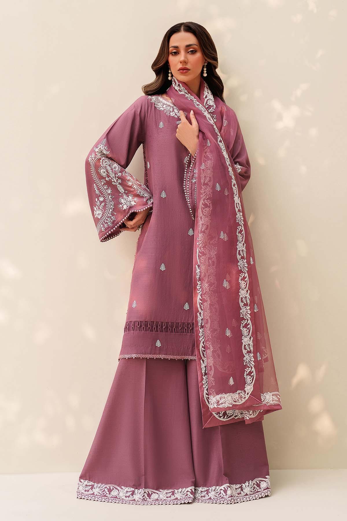 Woman wearing a mauve traditional outfit with white embroidery on a beige background