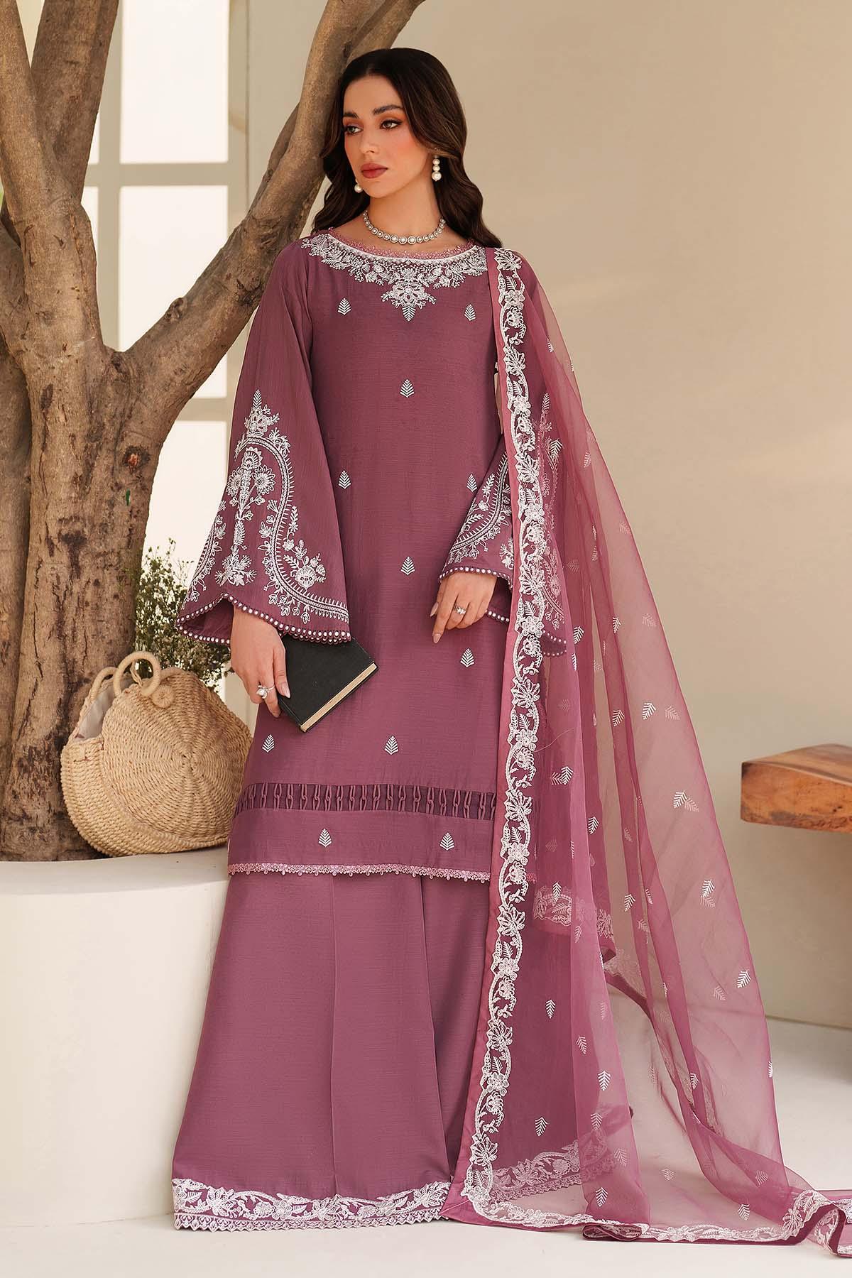 Woman wearing a mauve embroidered outfit with a sheer dupatta in a well-lit room.