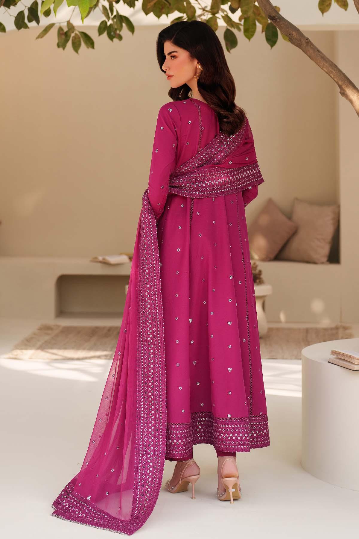 Woman in a pink traditional outfit with a matching dupatta in an outdoor setting.
