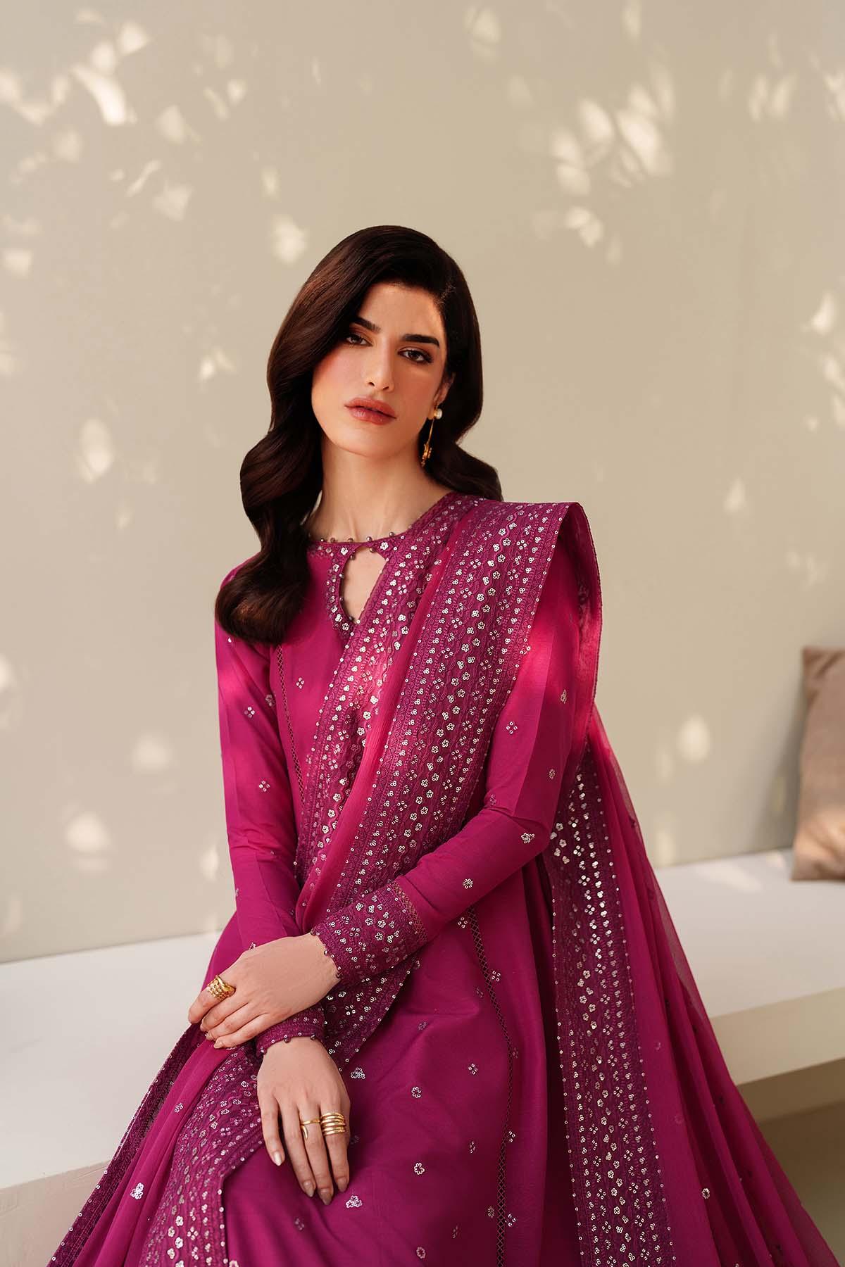 Woman wearing a pink traditional outfit with a matching dupatta against a neutral background