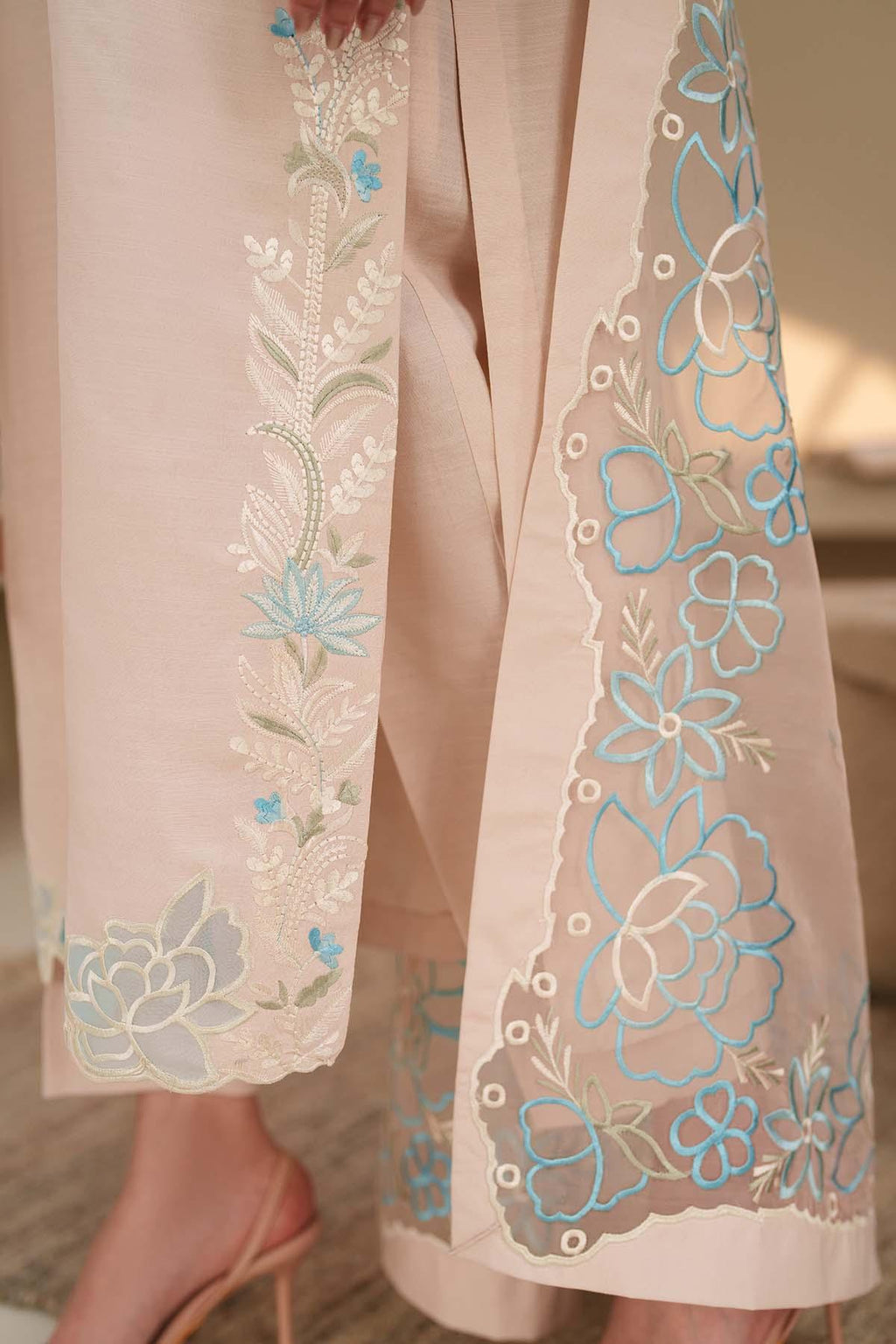 Light pink outfit with floral embroidery on a neutral background