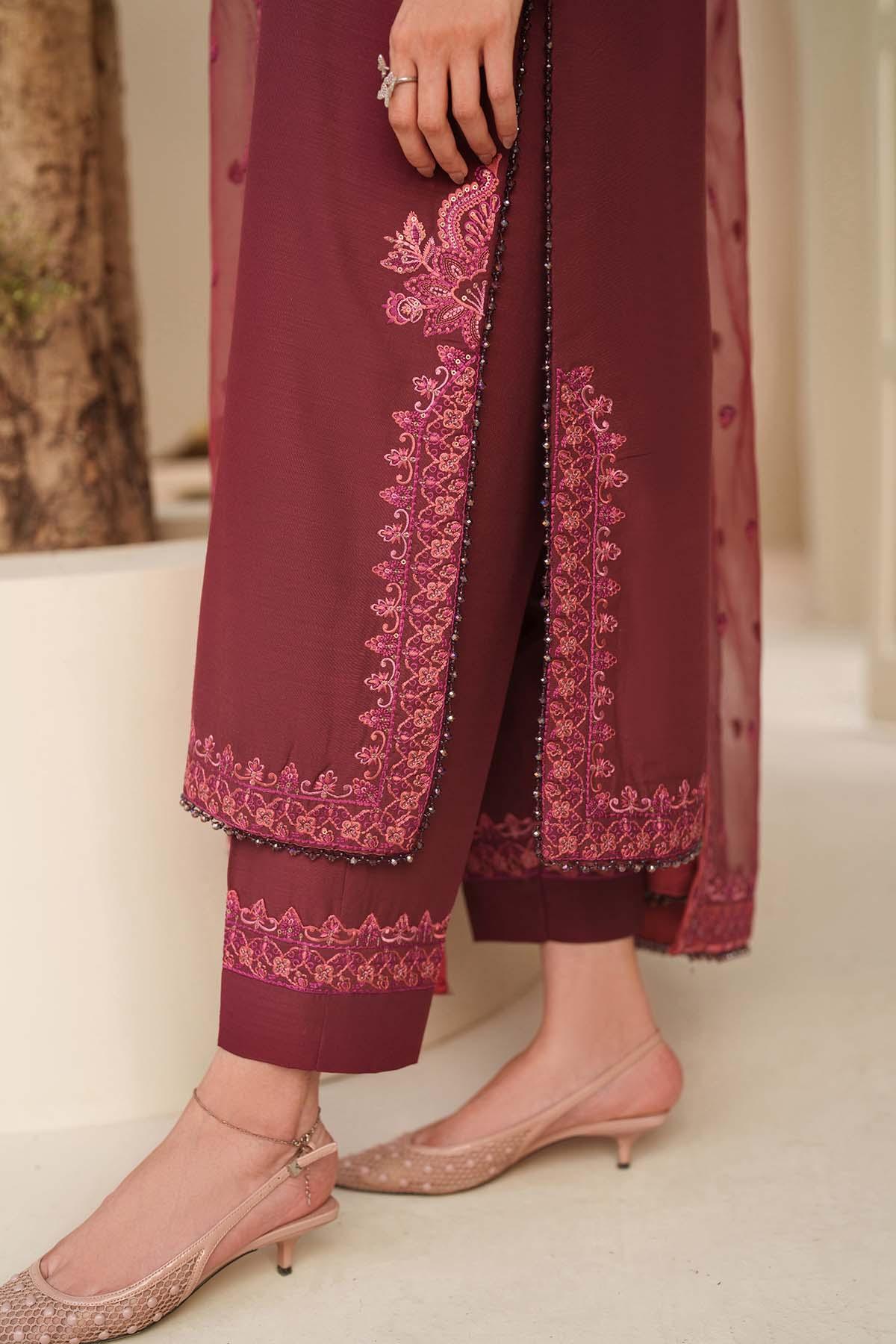 Maroon embroidered outfit with pink shoes on a neutral background