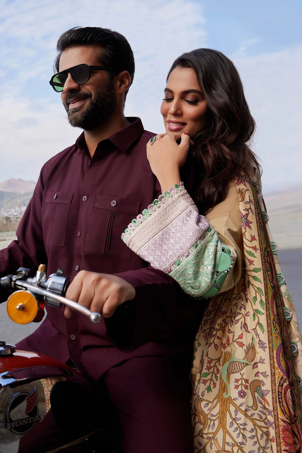 Man and woman on a motorcycle with scenic background