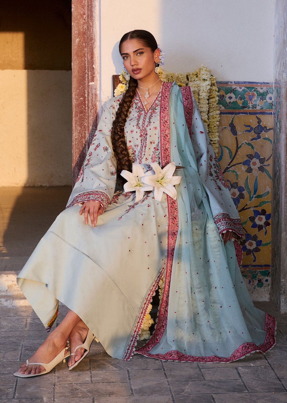 Woman in traditional attire with floral decorations in an outdoor setting
