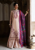 Woman in traditional outfit with embroidered top and colorful dupatta standing indoors.