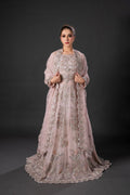 A woman wearing a traditional pink maxi set with embroidery and a dupatta lehnga blouse, against a neutral background.