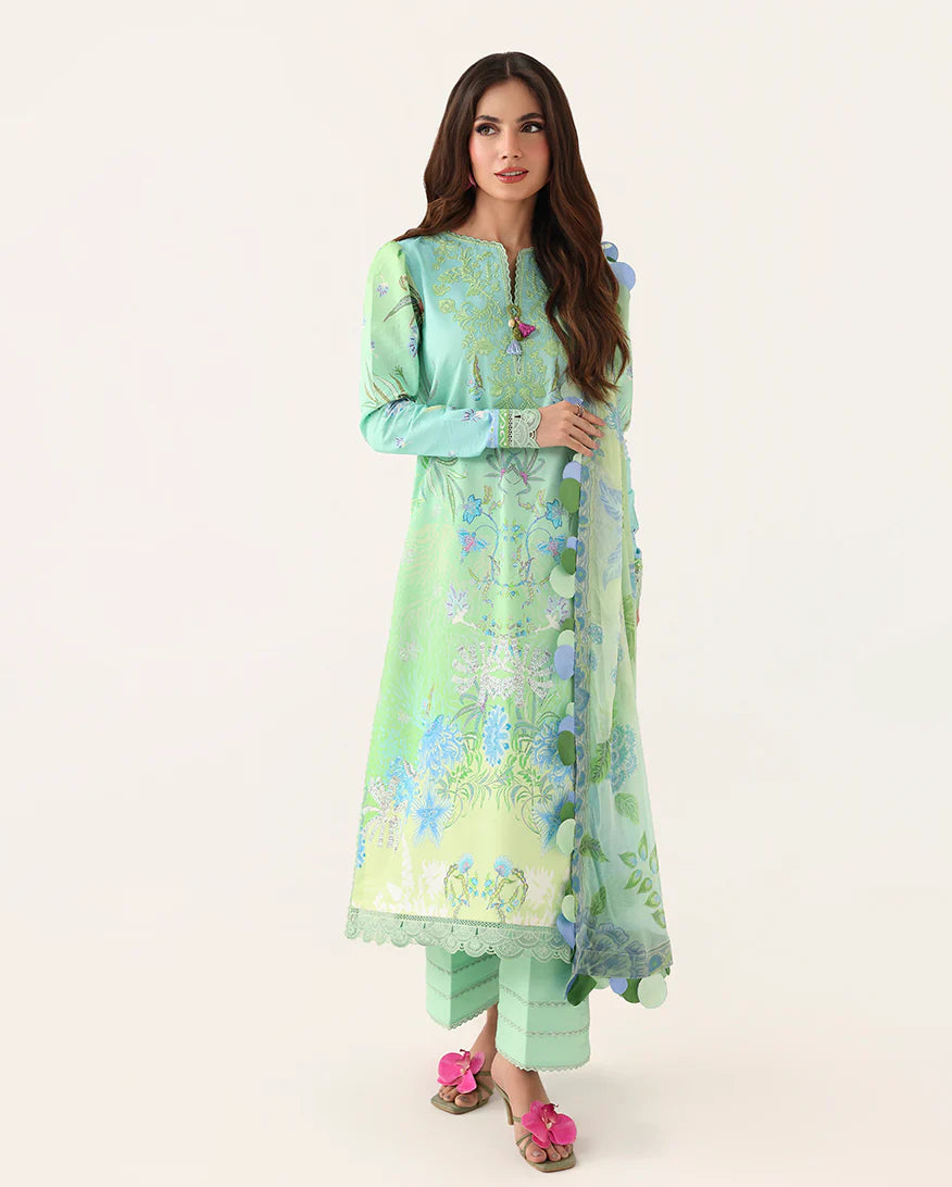 Woman wearing a light green floral dress with a matching dupatta on a white background