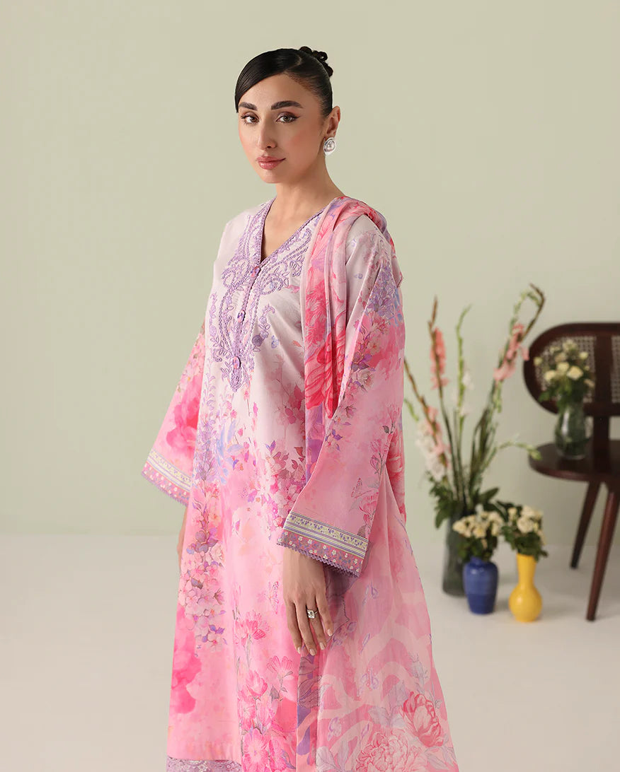 Woman wearing a pink and white floral outfit with a light background