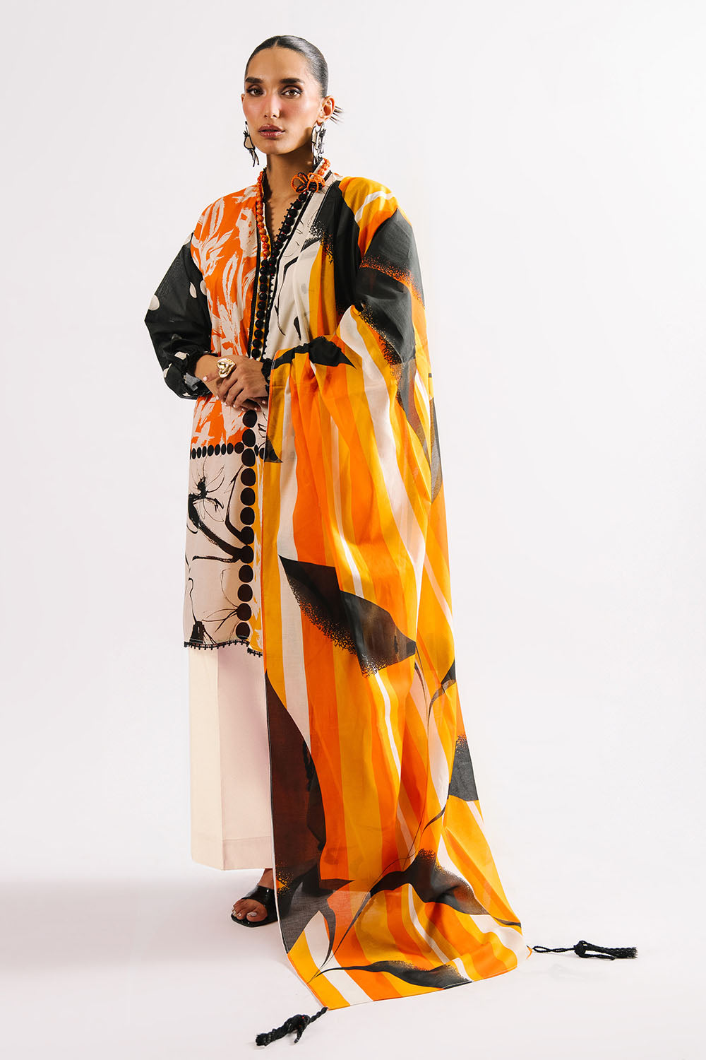 Woman wearing a colorful dress with abstract patterns on a white background
