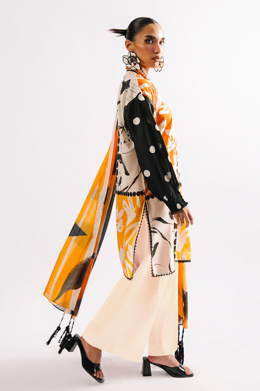 Woman wearing a long, patterned scarf with a white background