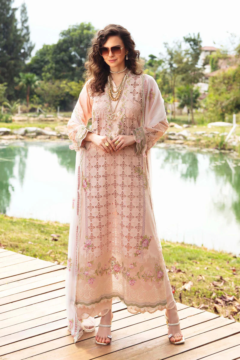 Woman in a floral dress standing on a wooden deck by a pond with trees in the background