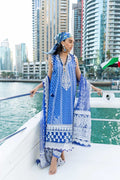 Woman in a blue and white traditional outfit on a boat with city skyline in the background