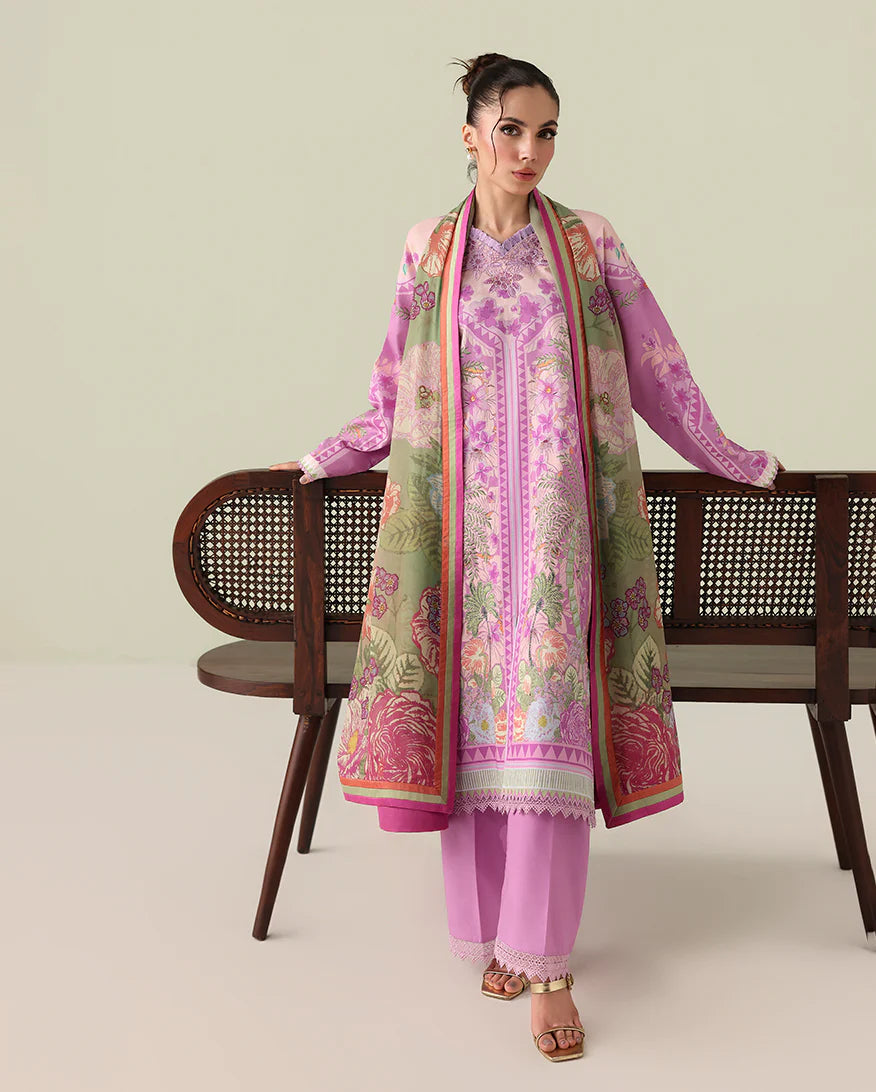 Woman wearing a pink and green embroidered traditional outfit with a matching dupatta, standing against a neutral background.