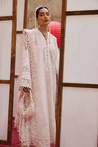 Woman in a traditional embroidered outfit with a red lantern in the background