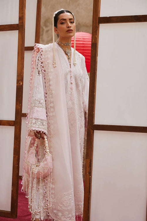 Woman in a traditional embroidered outfit with a red lantern in the background