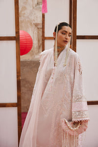Person wearing a traditional white embroidered outfit with a red lantern in the background