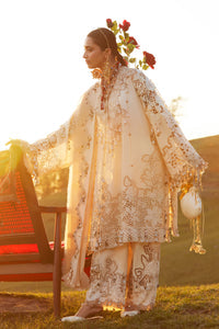 Woman in a white embroidered outfit standing outdoors with a blurred background