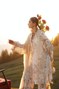 Woman in a traditional embroidered outfit standing outdoors with a scenic background