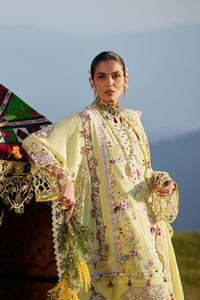 Woman in traditional yellow embroidered outfit standing outdoors with a scenic background