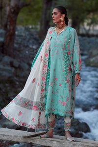 Woman in a floral outfit standing by a stream