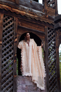 Woman in a flowing dress standing in a wooden architectural structure