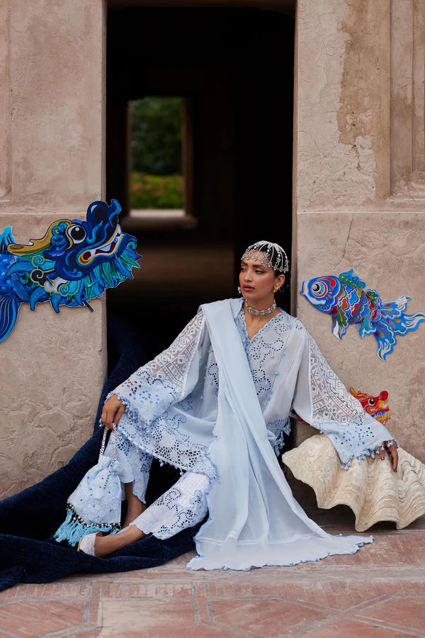 Woman in a traditional outfit sitting on a decorative chair with colorful wall art in the background.