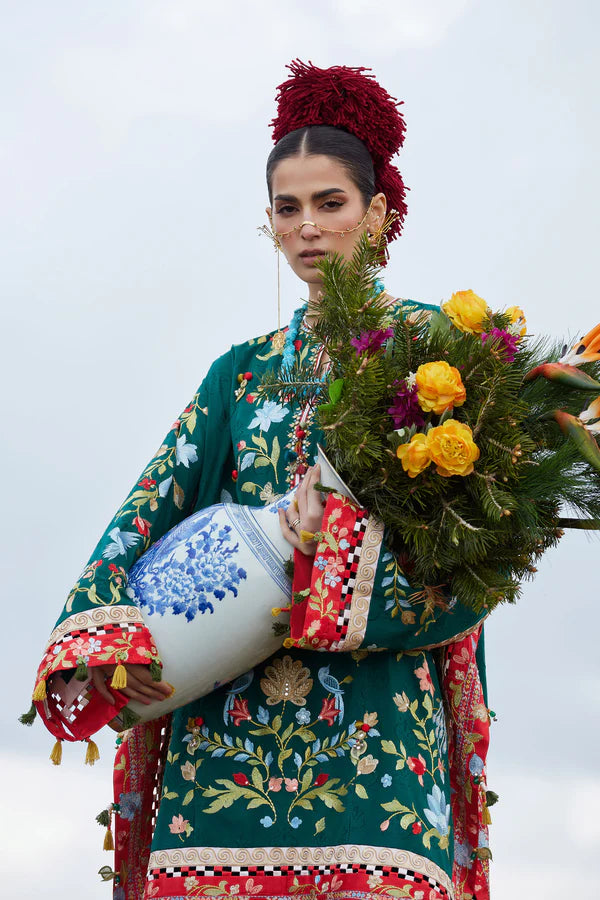 Woman in traditional embroidered outfit holding a floral arrangement against a white background