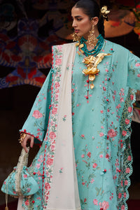 Woman wearing a turquoise embroidered outfit with gold jewelry against a colorful background